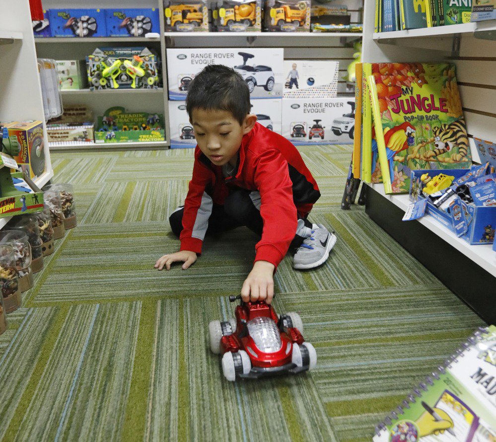 Paxton Mathis, 8, plays with a remote car at Time 4 Toys, in Flowood, Miss. The youngest child of the owner, Paxton, who has sensory processing disorder, often tests out some of the multipurpose toys for sale.