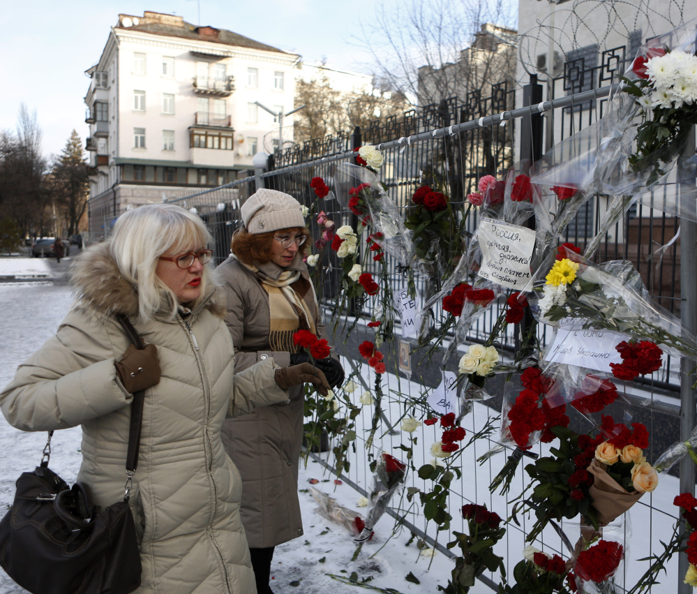 Women put flowers in front of the Russian embassy in Kiev, Ukraine, on Monday in memory of the passengers and crew who died in the crash of a military jet.