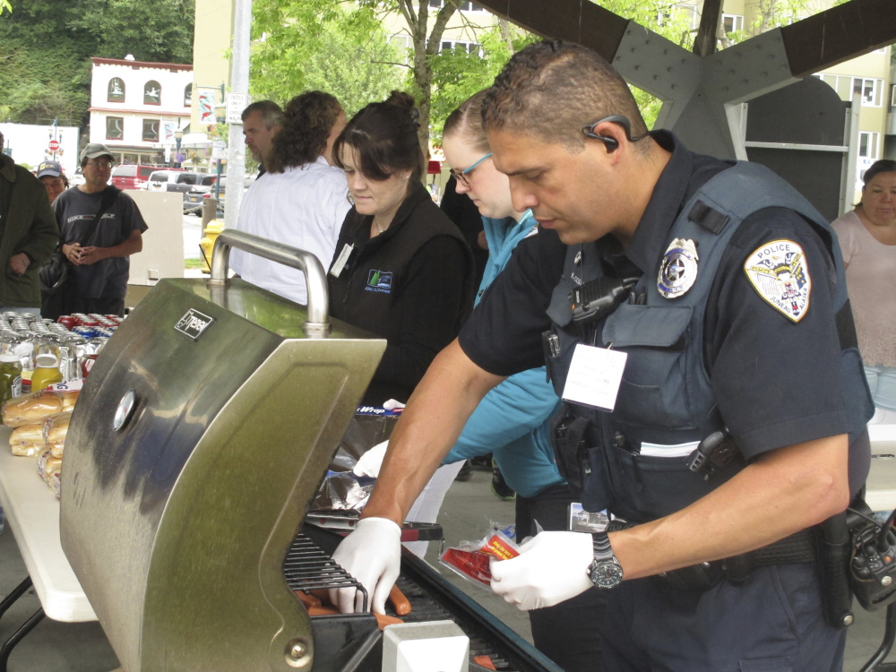 Juneau Police Officer Ken Colon grills hot dogs last July during a gathering sponsored by the police department to let people take a stand against violence.
