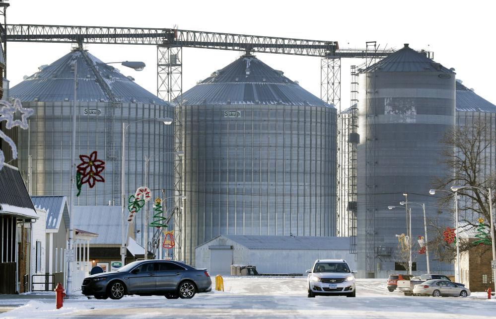 A motoristr passes the grain elevator this month in Renwick, Iowa. When the once-bustling town's sole bar closed this year, a group of friends pooled their money to repair and reopen the place as the Blue Moose Saloon.