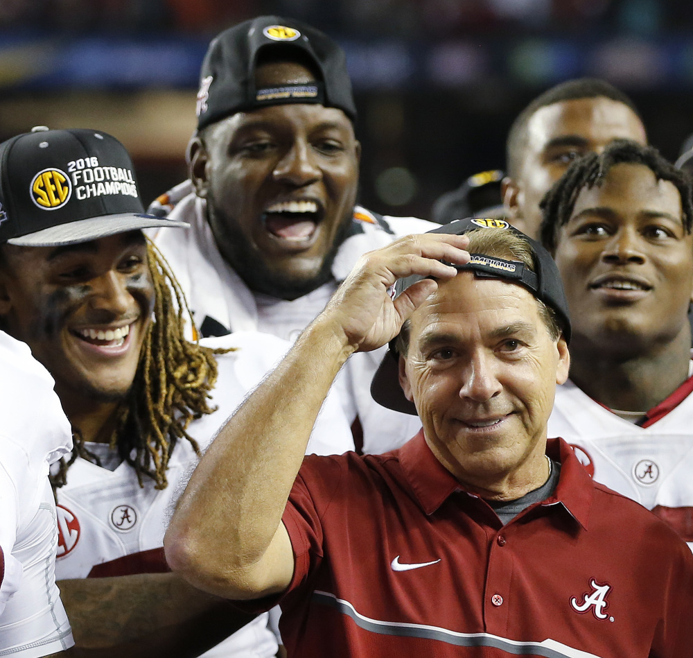 Alabama head coach Nick Saban and team members celebrate after the Southeastern Conference championship game against Florida on Saturday in Atlanta. Alabama won 54-16 and will be the No. 1 seed in this year's College Football playoffs.