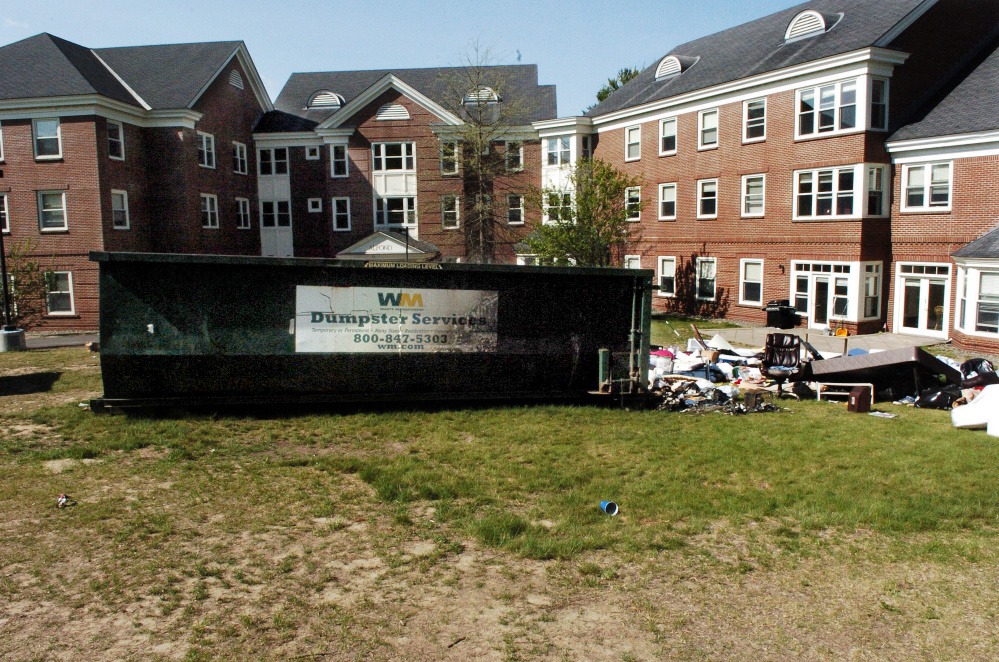 A charred Waste Management dumpster loaded with items from Colby College students is seen May 23 outside the Alfond dormitory on the college campus in Waterville. Three former Colby students on Tuesday pleaded guilty to criminal mischief charges in connection with the fire.