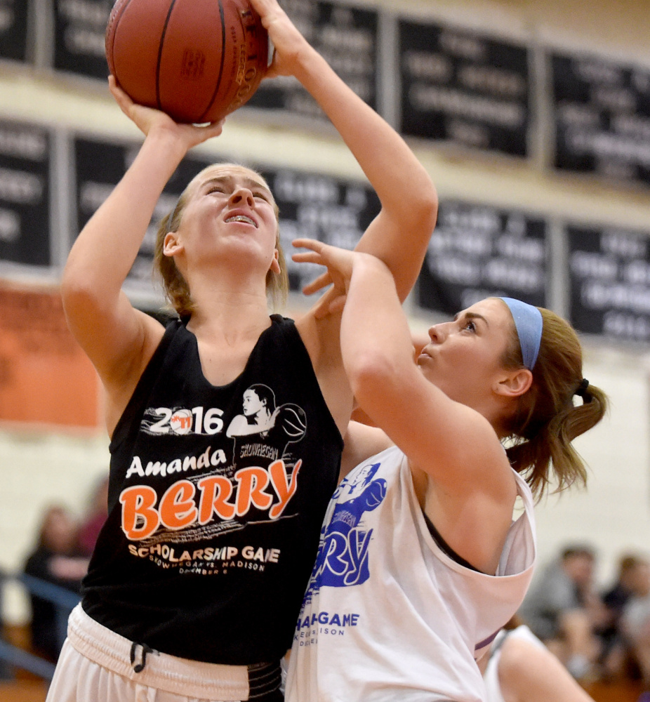 Skowhegan's Annie Cooke, left, draws a foul from Madison defender Marah Hall during the second annual Amanda Berry Scholarship game on Tuesday night in Skowhegan.