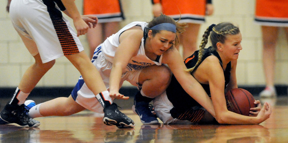 Madison's Marah Hall, left, battles for a loose ball with Skowhegan's Sydney Reed during the second annual Amanda Berry Scholarship game on Tuesday night in Skowhegan.