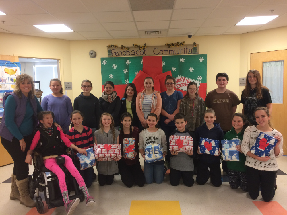 Deb Tanner, Somerset County's Teacher of the Year for 2015, left, worked with members of the Skowhegan Area Middle School student council to wrap gifts of pajamas and books for area children for Christmas as part of Tanner's Sweet Dreams Project to fight poverty.