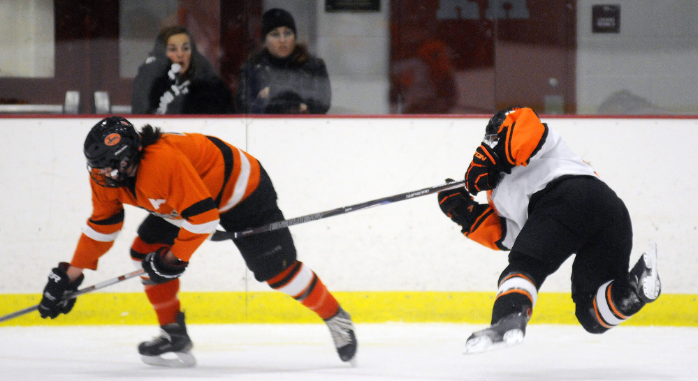 Winslow/Gardiner's Gabrielle Hebert, right, collects two minutes for slashing Brunswick's Beth Labbe during a girls hockey game Wednesday night in Kents Hill.