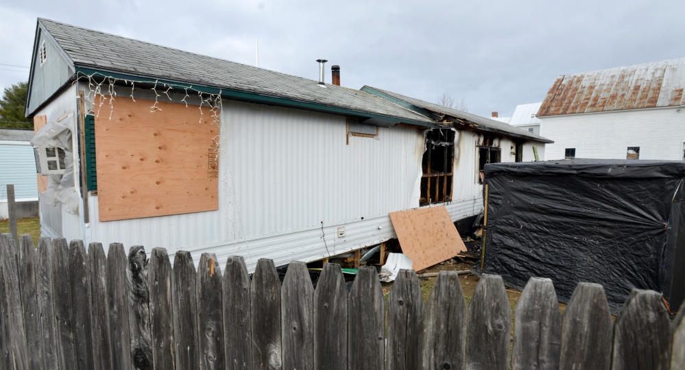 The rear side of a mobile home on North Avenue in Skowhegan is seen Saturday after having caught fire the previous night, injuring a child and mother.