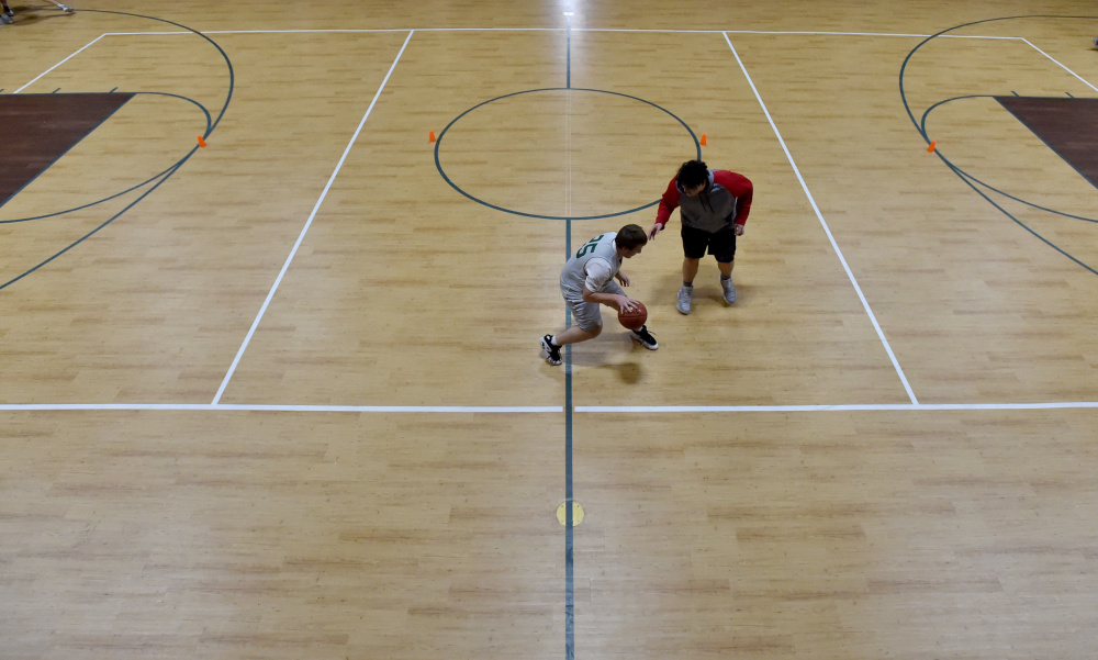 Members of the Temple Academy boys basketball team practice on its new hardcourt Thursday.