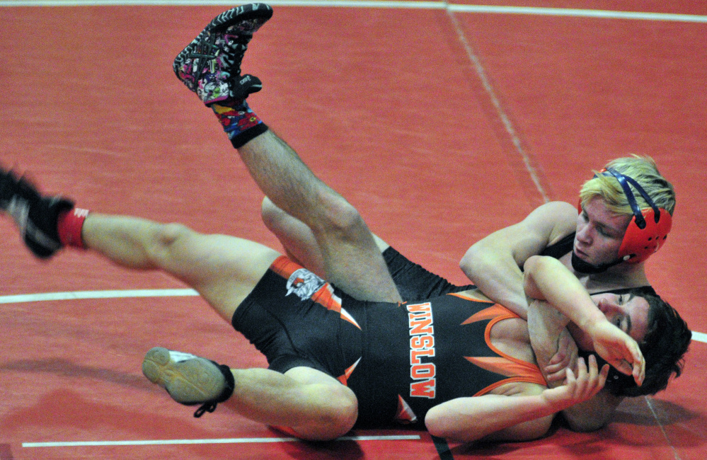 Tight grip: Skowhegan's Cody Craig, top, grapples with Winslow's Devon Vigue on his way to winning the 113-pound championship at the Kennebec Valley Athletic Conference championships last season at Cony High School.