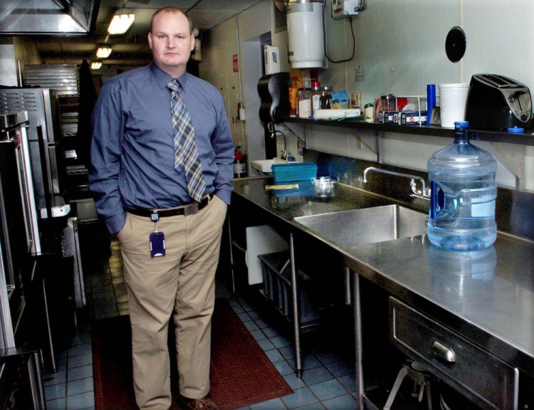 Benton Elementary School Principal Brian Wedge stands beside the school cafeteria's kitchen sink, where exceptionally high levels of lead were detected in October, but further testing has revealed lower levels.