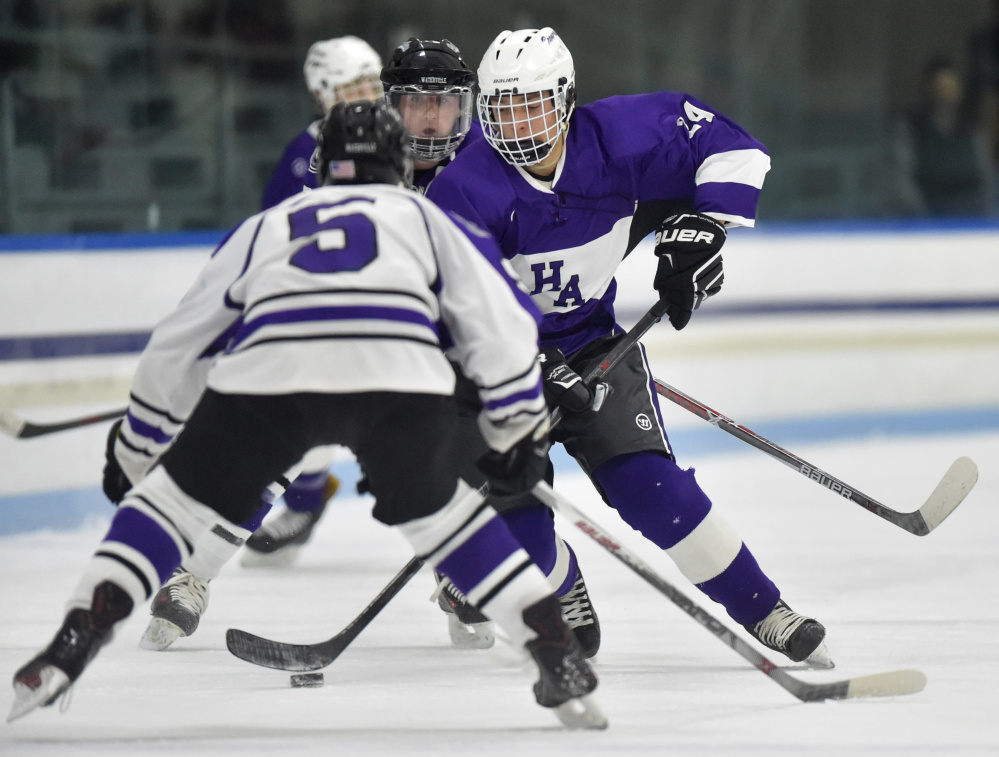 Waterville Senior High School's Andrew Roderigue (5) defends Hampden Academy's Joey McLain in the first period at Alfond Rink on Saturday night. 