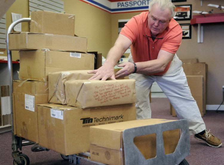 Keith McCray stacks packages to ship Wednesday at the Mailing Center in Augusta.