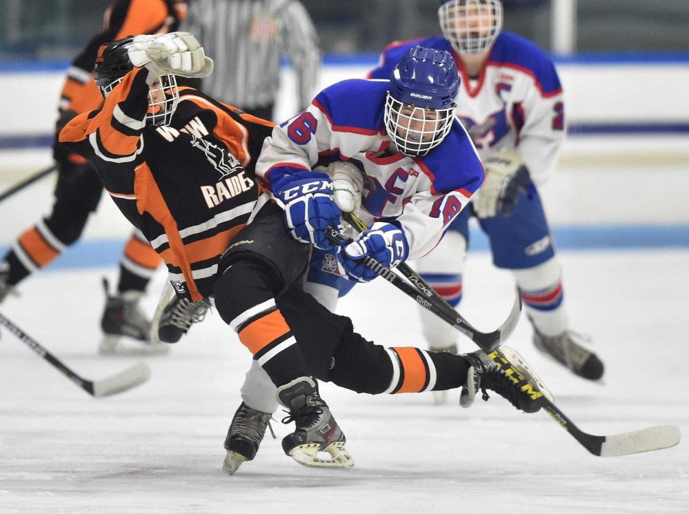 Messalonskee forward Jack Moore, right, checks Winslow's Logan Denis  during the first period of a Class B North game Wednesday night at Colby College in Waterville.