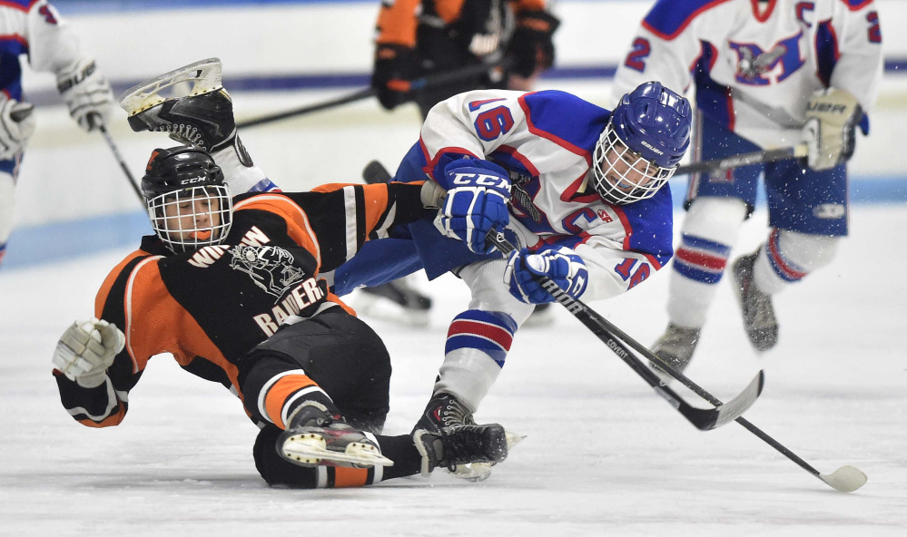 Messalonskee's Jack Moore, right, checks Winslow's Logan Denis during the first period of a Class B North game Wednesday night at Colby College in Waterville.