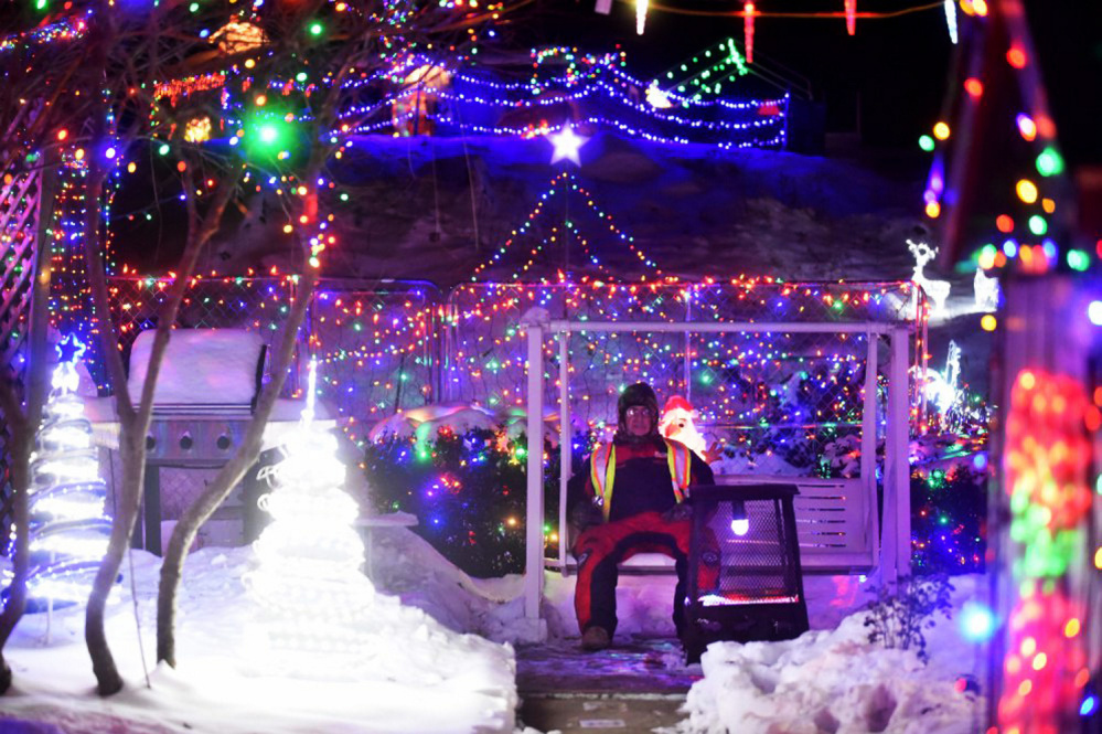 Donald Lagasse sits on Thursday among the many thousands of lights on display at his home, which is part of the China Road Christmas Park, on China Road in Winslow.