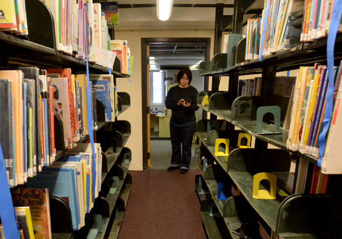 Tammy Rabideau, assistant director at the Waterville Public Library, stands among damaged books Saturday in the library's children's section in Waterville.