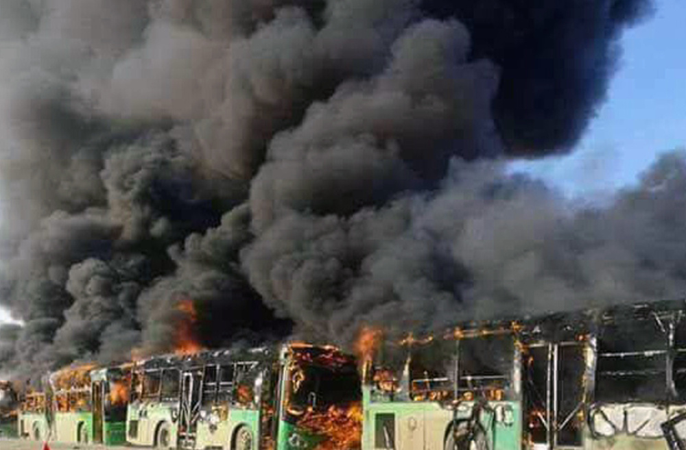 Smoke rises over burning government buses in Syria on Sunday. Activists said militants have burned at least five buses assigned to evacuate wounded and sick people.