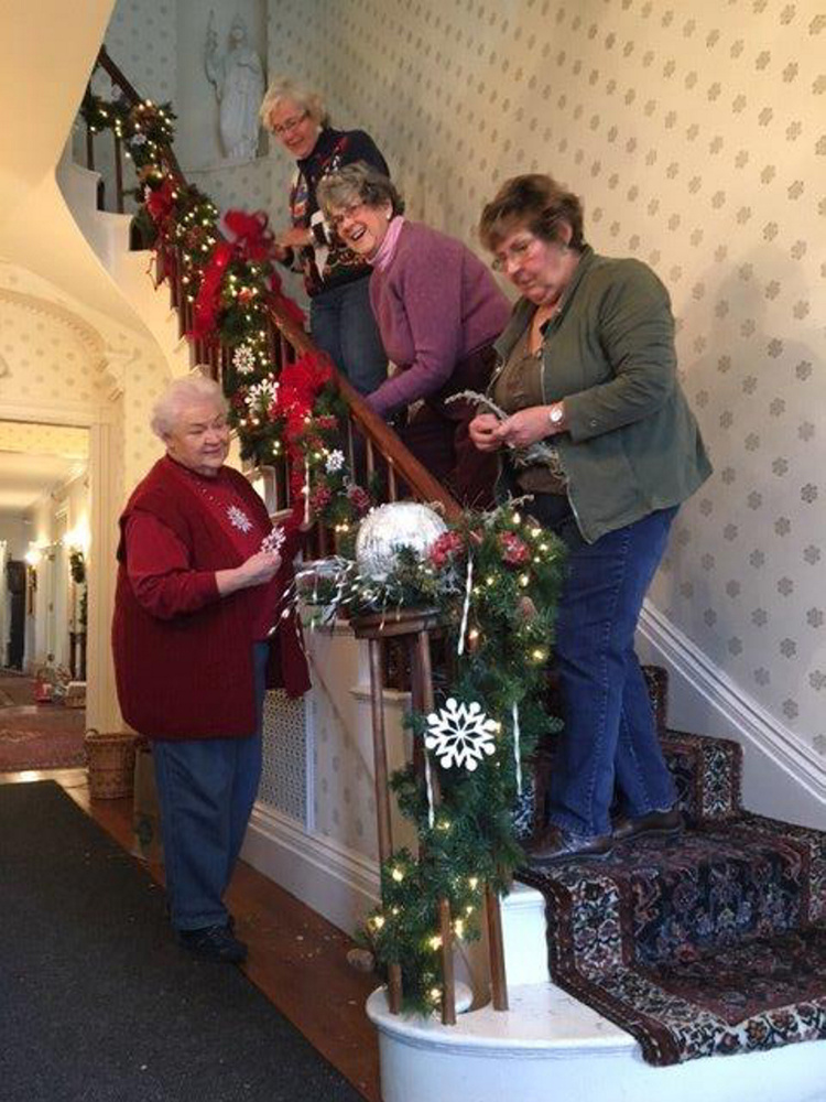 Kennebec Valley Garden Club members decorate the Blaine House stairway, front door entry and rooms in preparation for all the festivities during the holiday season. From top are Debbie Sherman, Joan Hague, Karen Foster and Jean Matheson.