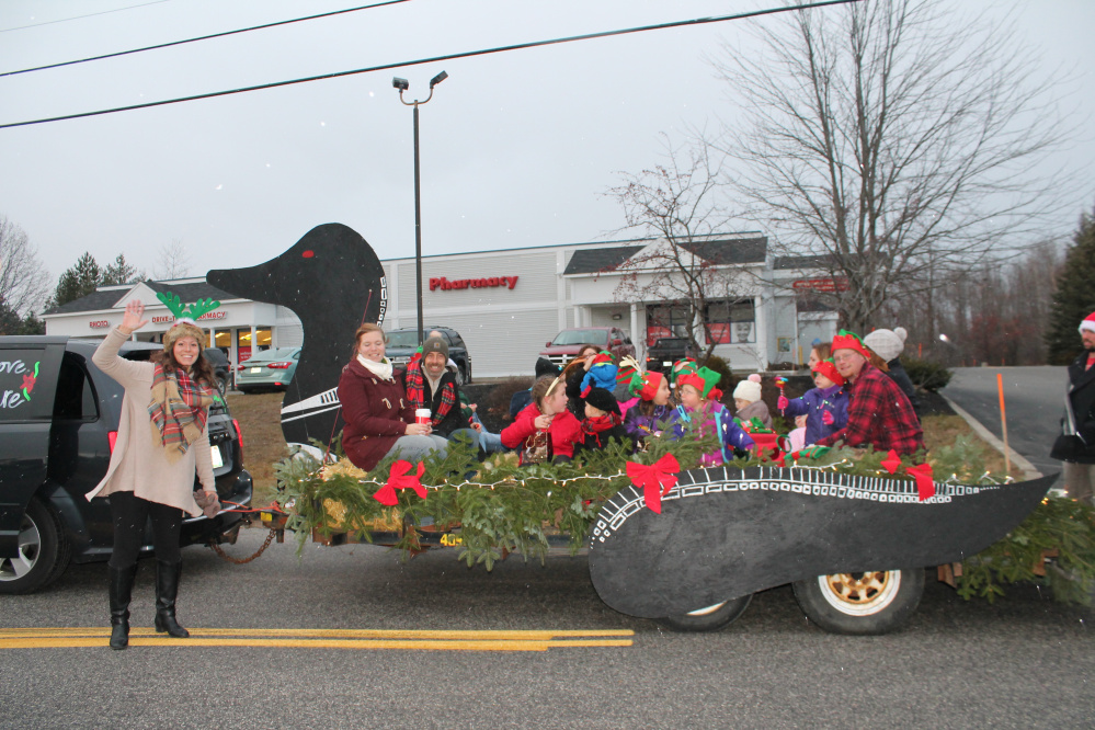 Keltie Beaudoin, owner of Loon Cove Child Care in Winthrop, waves as she walks with a loon shaped float filled with the children attending her daycare.