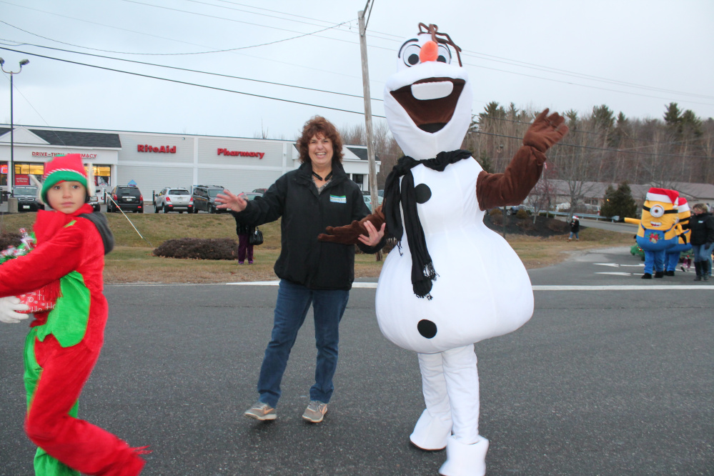Winthrop Area Federal Credit Union employee Sandy Labreck escorts Olaf in the parade.
