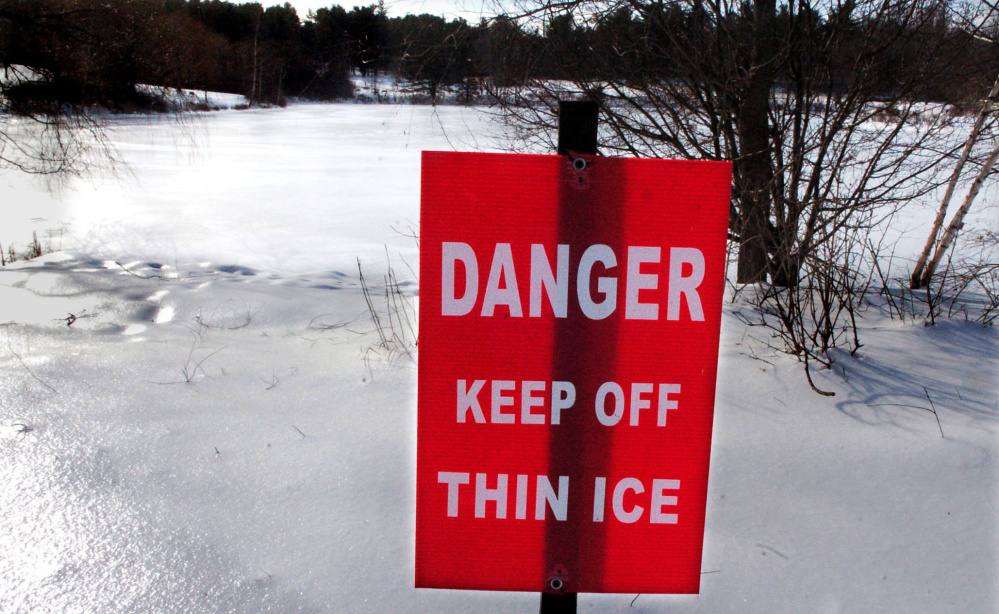 A sign standing Tuesday on the shore of Johnson Pond in Waterville warns skaters to stay off the ice, which might not be thick enough despite the recent cold weather. The Maine Warden Service also is warning fishermen to be cautious.