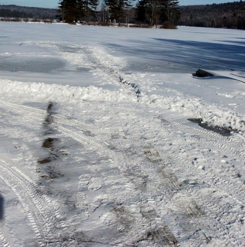 A boat landing on Tuesday shows evidence that a crew has plowed a path through the snow and onto the ice at Lake George Regional Park East in Skowhegan. The Maine Warden Service is warning ice fishermen and skaters to be wary of thin ice this early in the winter.