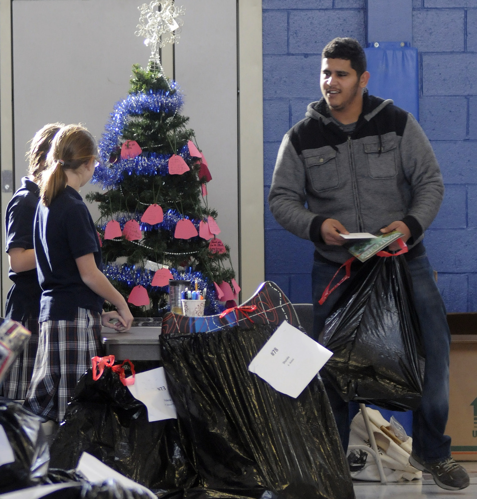 Malik Mousier collects gifts distributed by the Salvation Army on Tuesday at St. Michael School in Augusta.
