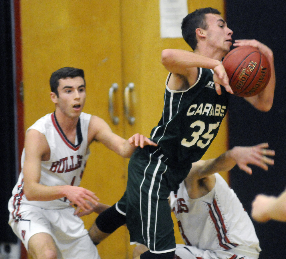 Hall-Dale's Ashtyn Abbott, right, and Tyler Nadeau, left, can't contain Carrabec's Dustin Crawford during a Mountain Valley Conference game Tuesday in Farmingdale.