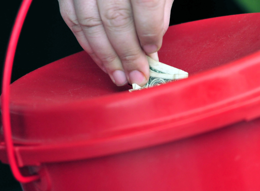 A donor stuffs money into a Salvation Army red kettle in December 2014.