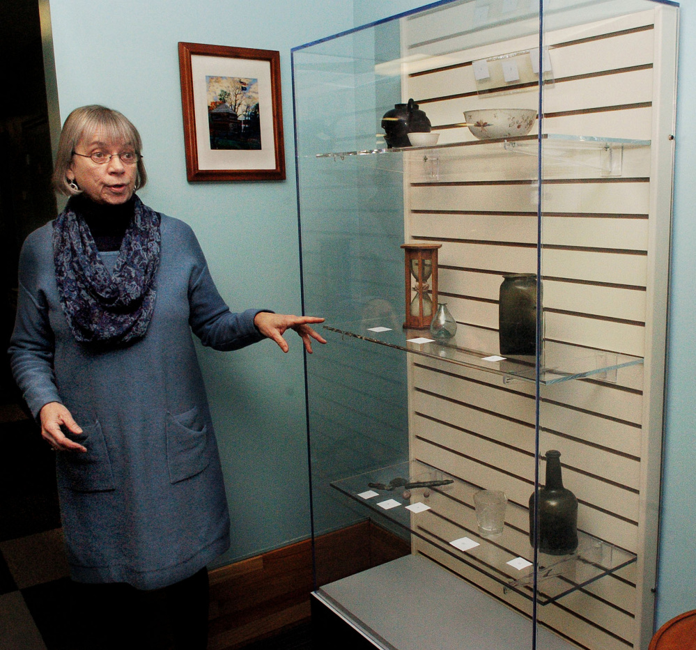 Winslow Public Library Director Pamela Bonney speaks about the library's new archival exhibit case, which contains items from the Fort Halifax Archaeological Collection, on Wednesday. The case allows old and sensitive items to be stored in a protective environment.