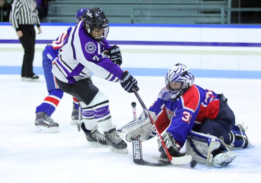 Waterville's Zach Menoudarakos tries to put the puck past Messalonskee  goalie Amber Kochaver during second-period action Thursday at Colby College in Waterville.