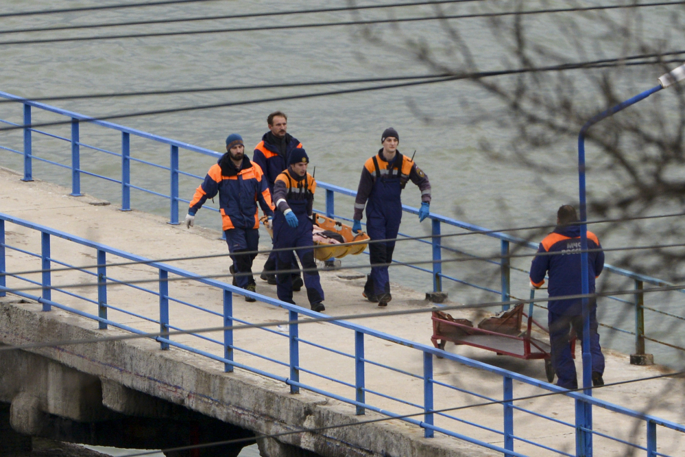Russian rescue workers carry a body from the wreckage of the crashed plane, at a pier just outside Sochi, Russia, on Sunday.