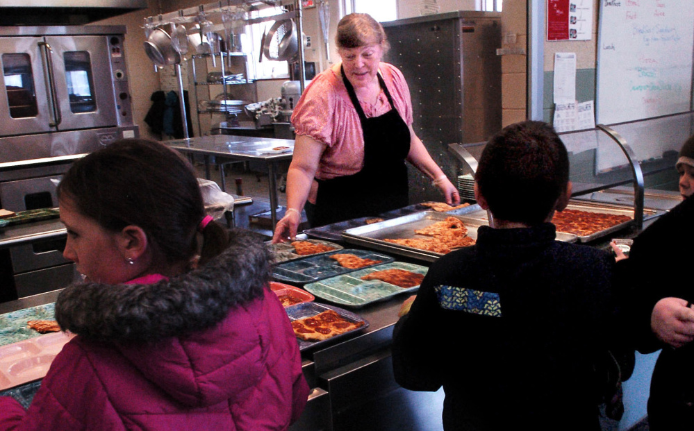 Winslow Elementary School food service employee Vicki Perry sets out lunches for students on Wednesday. Starting Jan. 3, the school will pilot a food-waste recycling program that involves the Agri-Cycle Energy processing plant in Exeter.