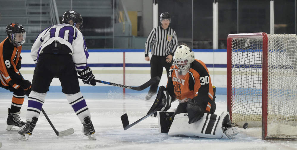 Winslow goalie Ben Grenier (30) can't make the save as Waterville's Matt Jolicoeur (10) looks for the rebound Tuesday at Colby College in Waterville.