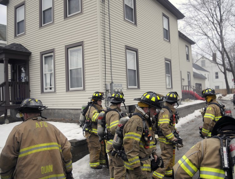 Augusta firefighters gather on Wednesday outside a building on Winthrop Court in Augusta after the building's boiler overheated, sending smoke into the two-unit house.