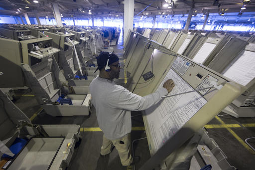 A technician prepares a voting machine for use before November's U.S. election.