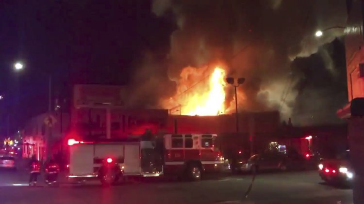 This photo taken from video provided by @Oaklandfirelive shows the scene of a fire in Oakland early Saturday.