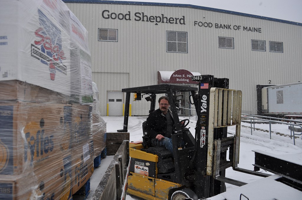 John Russell, a staffer at the Good Shepherd Food Bank warehouse in Auburn, moves foodstuffs. The facility is named for Good Shepherd founder JoAnn Pike, who started a food bank in her home in 1981.