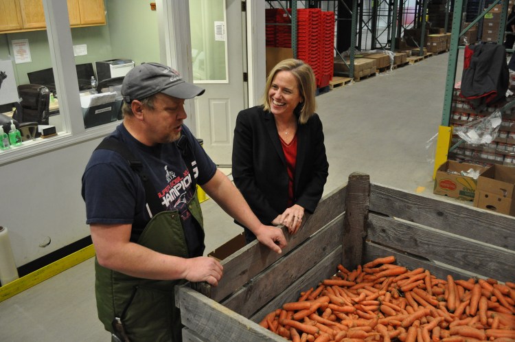 Good Shepherd Food Bank of Maine President Kristen Miale and warehouse staffer Rusty Cooper look over produce at the nonprofit’s distribution center in Auburn. (Photo by Ryan Fecteau.)