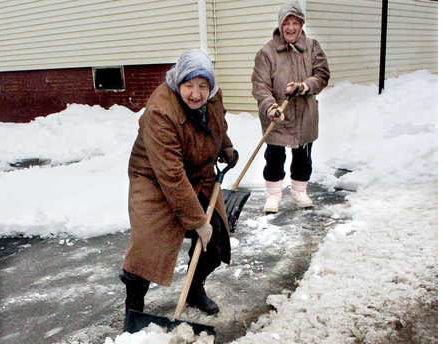 Marie Poulin, left, and her sister Rita shovel heavy slush in front of their home in Waterville on Sunday. 
David Leaming/Morning Sentinel
