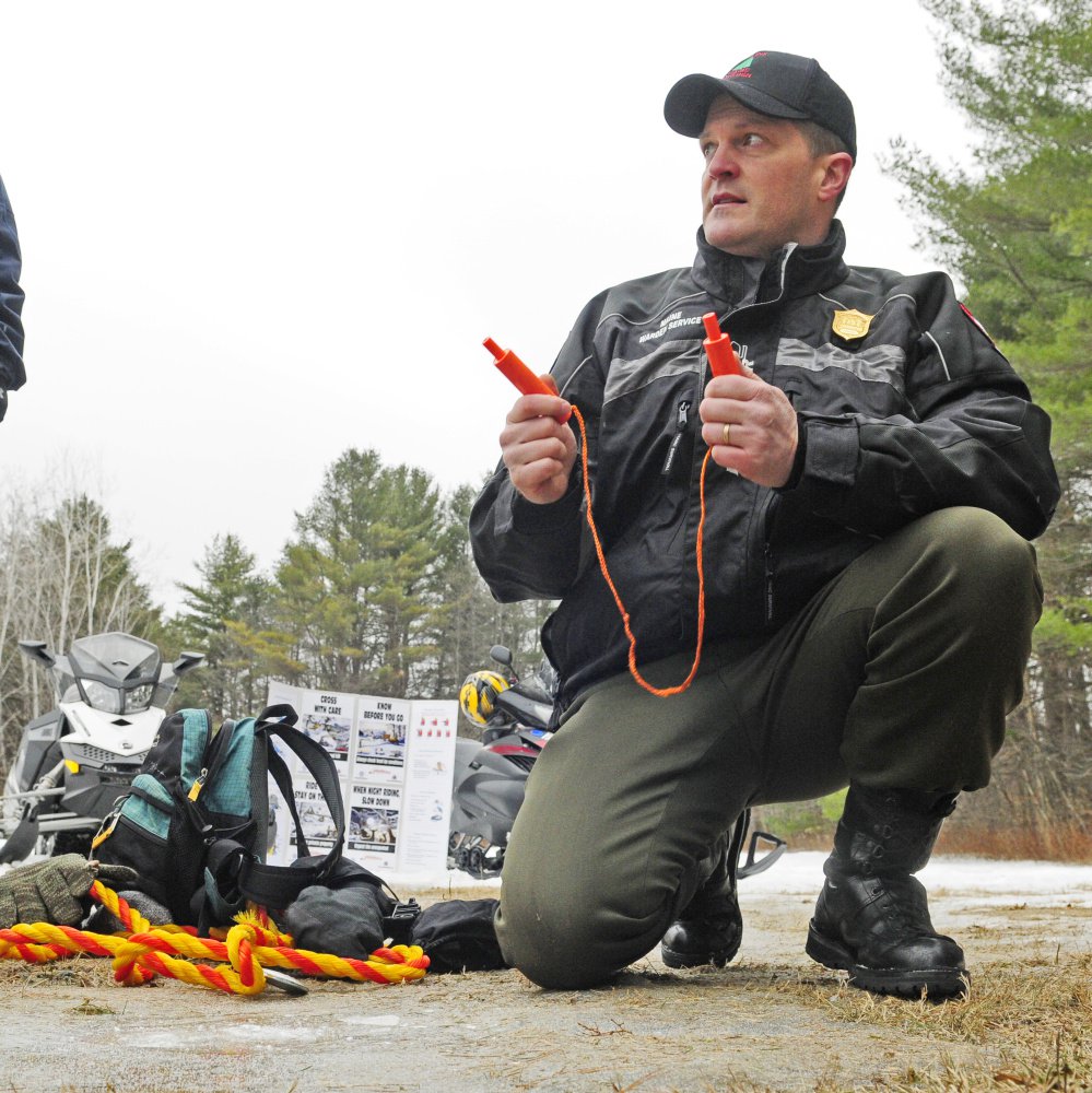 Maine Warden Service Cpl. John MacDonald holds up ice picks while talking during Thursday's news conference about why snowmobilers should carry packs with safety gear, food and dry clothes.