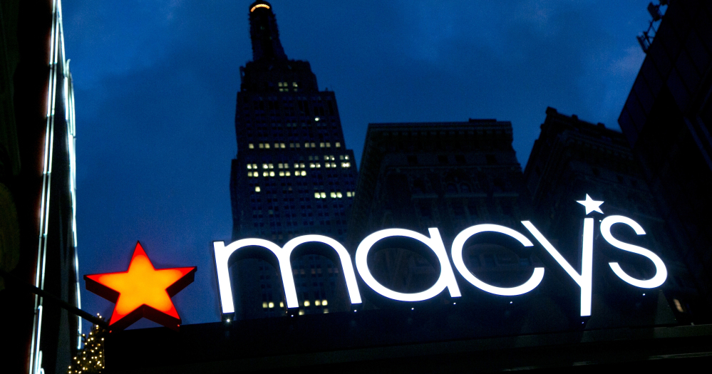 With the Empire State Building in the background, the Macy's logo is illuminated on the front of the flagship department store in New York.
