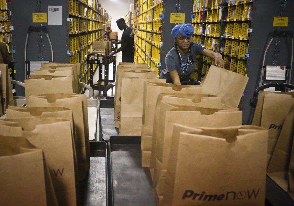 Amazon PrimeNow workers fill orders from customers at a distribution center in New York. Amazon is planning to hire 100,000 workers in the U.S. over the next 18 months, and many of them will be at new fulfillment centers being built in states such as California, Florida and Texas. The company is also adding to its delivery capabilities.