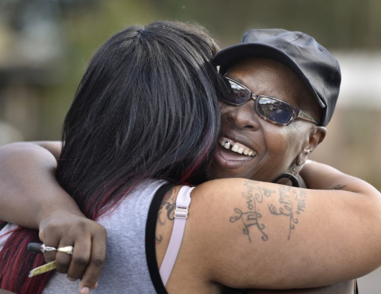 Velma Aiken, the paternal grandmother of Kamiyah Mobley, who was kidnapped as an infant 18 years ago, gets a congratulatory hug from a family member after Mobley was found safe, Friday in Jacksonville, Fla.