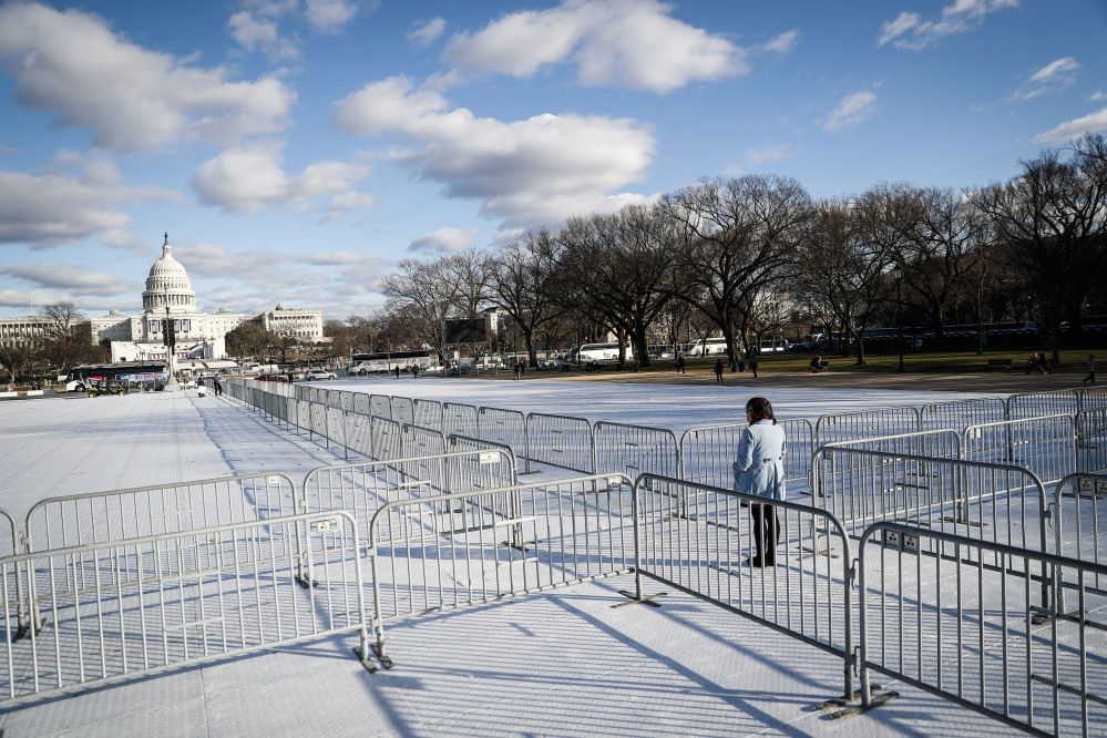 A pedestrian stand at the intersection of barricades dividing areas of standing room on the National Mall in Washington, Wednesday, Jan. 18, 2017, as preparations continue for Friday's presidential inauguration. (AP Photo/John Minchillo)