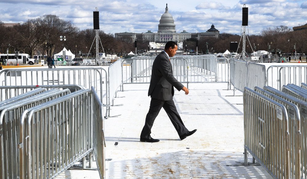 A pedestrian walks through the National Mall in Washington, Wednesday as the Capitol readies for Friday's crowds.