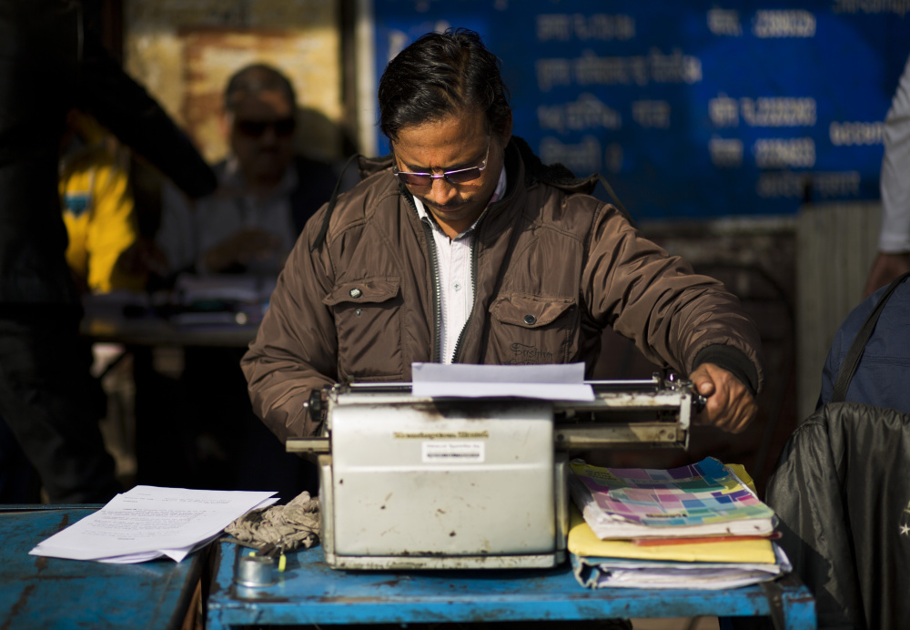 A roadside professional typist works near the stock exchange market in New Delhi, India. India still has a few thousand remaining professional typists, but even here, one of the last places in the world where the typewriter remains a part of everyday life, the end is coming.