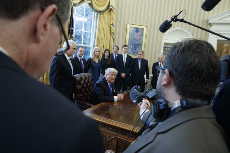 President Trump answers a question after signing a series of executive orders on Tuesday in the Oval Office of the White House in Washington. The administration has instructed officials at the Environmental Protection Agency to freeze its grants and contracts, and to black out all media communications.