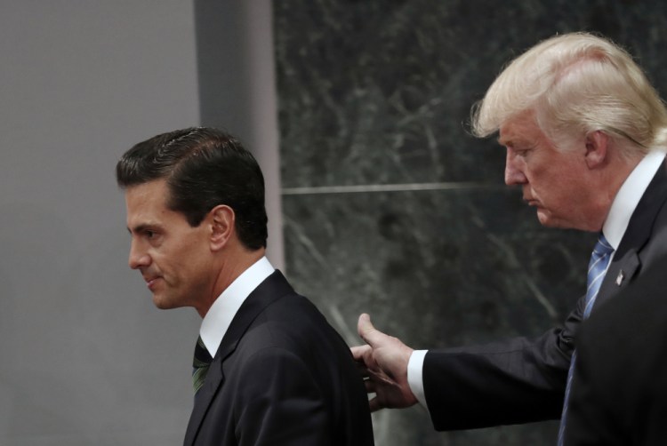 Then-Republican presidential nominee Donald Trump walks with Mexican President Enrique Peña Nieto at Los Pinos, the presidential official residence, in Mexico City in August 2016. Trump and Peña Nieto spoke for an hour by phone Friday amid rising tensions over the U.S. leader's plans for a southern border wall, administration officials said.