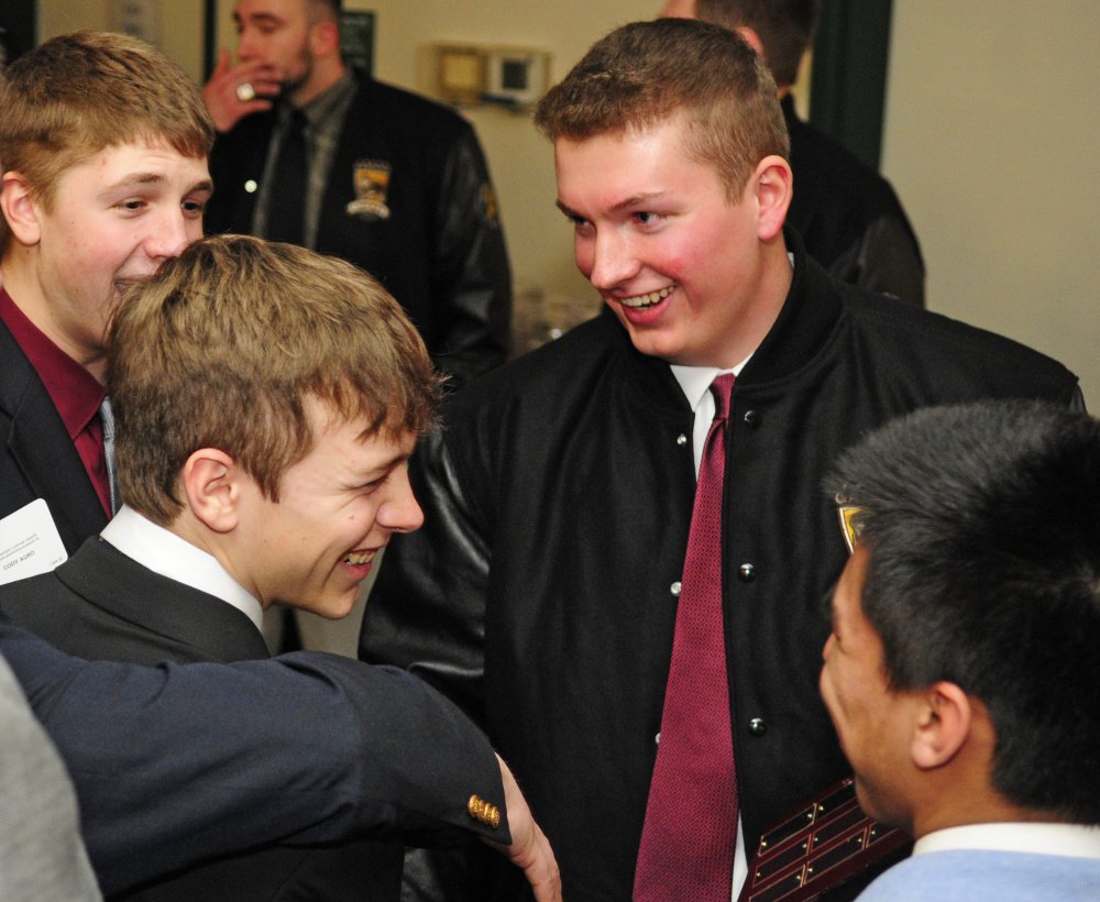 Thornton Academy's Nicholas Bartholomew, top right, is congratulated by teammates after winning the 2016 the Frank Gazianao Offensive Lineman of the Year on Saturday at the Augusta Civic Center. (Staff photo by Joe Phelan/Staff Photographer)